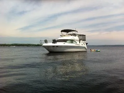 Slide: The Image of 1997 Sea Ray 370 Aft Cabin yacht on calm water under a cloudy sky. - 48