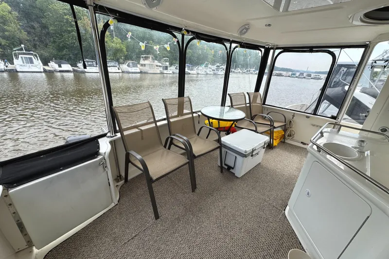 Slide: The Image of 1997 Sea Ray 370 Aft Cabin interior with chairs, table, and marina view. - 9