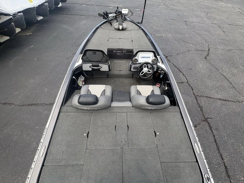 Slide: The Image of 2025 Skeeter FX 20 boat interior with steering wheel and seating, parked on asphalt. - 17