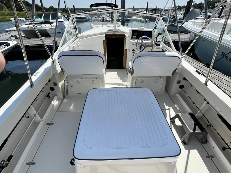 Slide: The Image of 2002 Limestone 24 Cuddy Cabin boat interior with white seating and steering console. - 10
