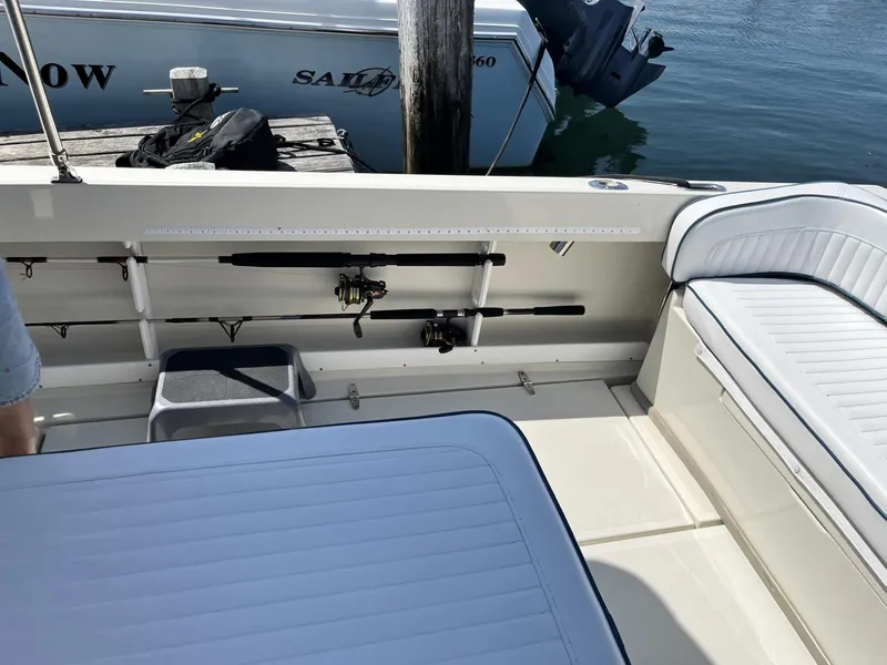 Slide: The Image of 2002 Limestone 24 Cuddy Cabin interior with fishing rods and seating. - 12