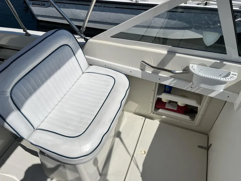 Slide: The Image of Interior of a 2002 Limestone 24 Cuddy Cabin boat with white seating and storage. - 14