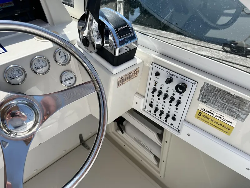 Slide: The Image of Control panel of a 2002 Limestone 24 Cuddy Cabin boat with steering wheel and gauges. - 19
