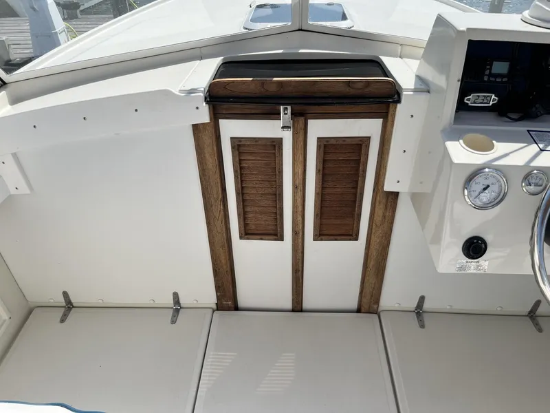 Slide: The Image of 2002 Limestone 24 Cuddy Cabin interior with wooden doors and control panel. - 20