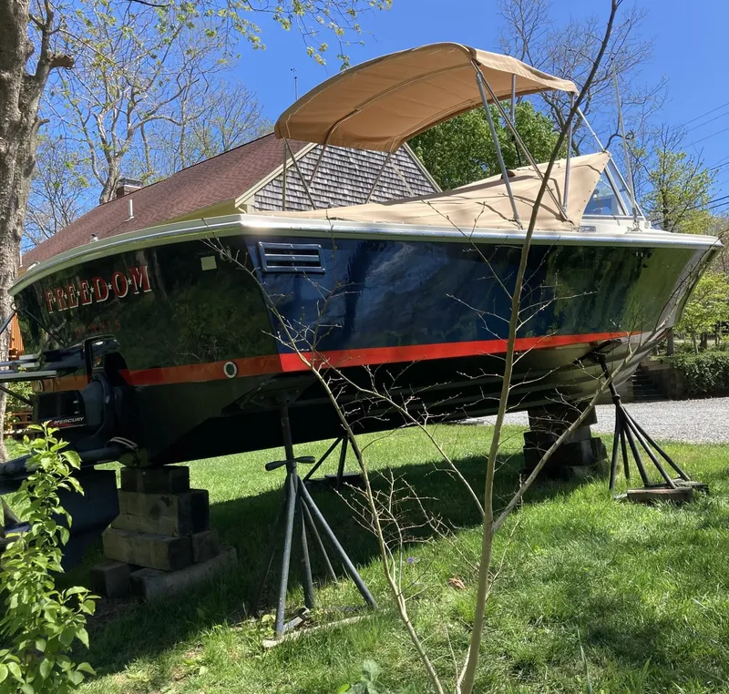 Slide: The Image of 2002 Limestone 24 Cuddy Cabin boat on stands, with canopy, in a grassy yard. - 5