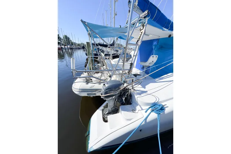 Slide: The Image of Catamaran TomCat 9.70 s, 2012 model, docked with blue canopy and Yamaha motor. - 14