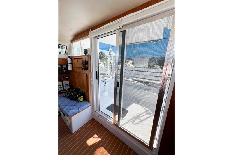 Slide: The Image of Interior view of 2012 TomCat 9.70 s boat with sliding door and seating area. - 16