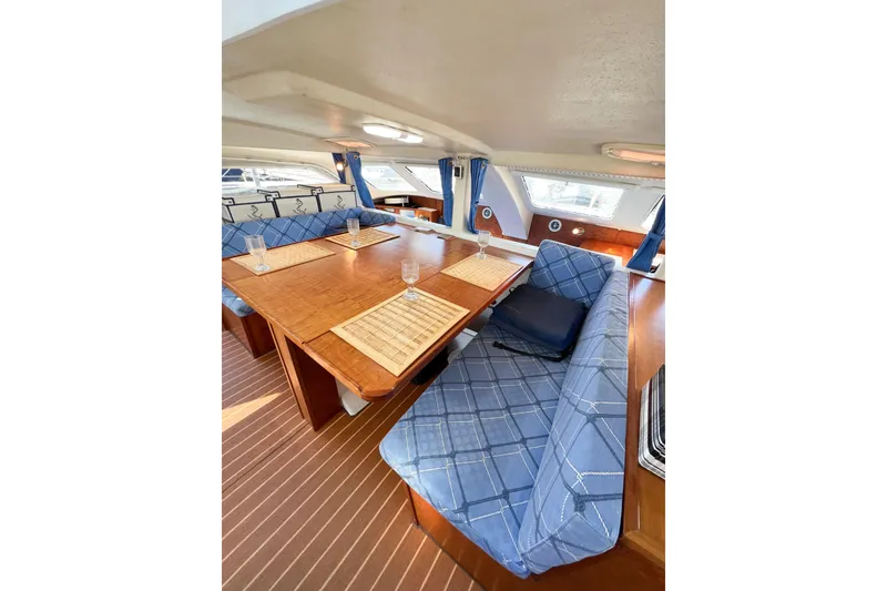 Slide: The Image of Interior of 2012 TomCat 9.70 s yacht with blue plaid seating and wooden table. - 22