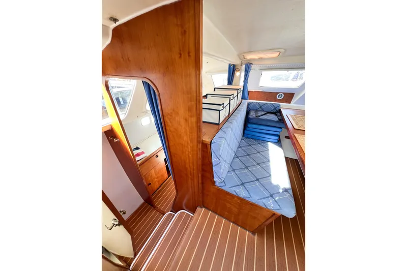 Slide: The Image of Interior of 2012 TomCat 9.70 s sailboat with wooden finish and blue seating. - 23