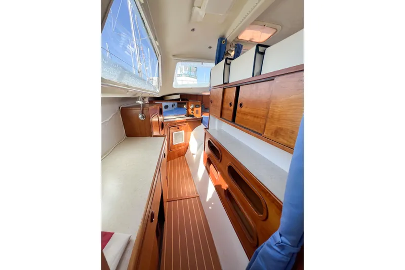 Slide: The Image of Interior of 2012 TomCat 9.70 s sailboat with wooden cabinetry and ample natural light. - 25