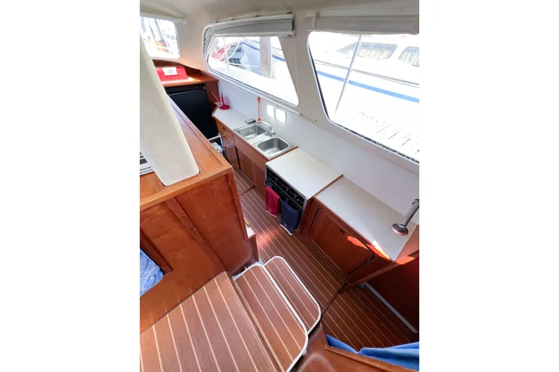Slide: The Image of Interior of 2012 TomCat 9.70 s boat with wooden flooring and compact kitchen area. - 29