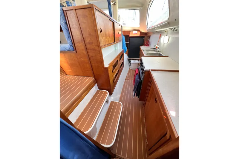 Slide: The Image of Interior of 2012 TomCat 9.70 s boat with wooden cabinetry and compact kitchen area. - 32