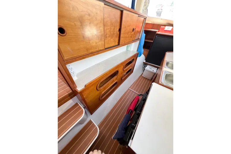 Slide: The Image of Interior of 2012 TomCat 9.70 s boat with wooden cabinets and compact kitchen area. - 33
