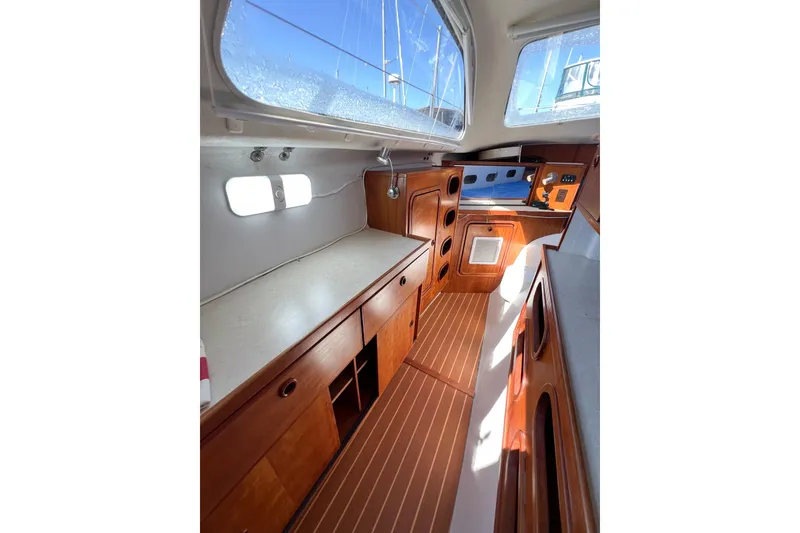 Slide: The Image of Interior of 2012 TomCat 9.70 s sailboat with wooden cabinetry and ample natural light. - 36