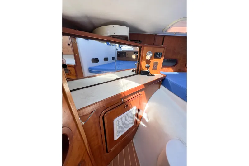 Slide: The Image of Interior of 2012 TomCat 9.70 s boat with wooden cabinetry and blue seating. - 38