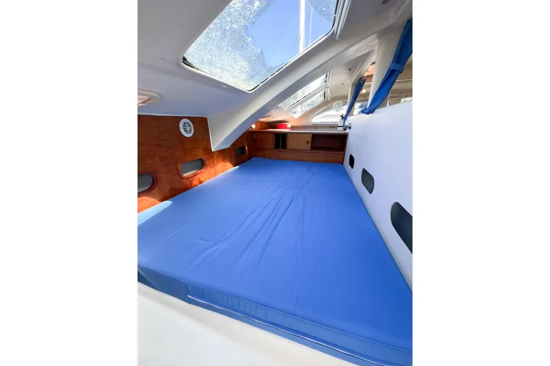 Slide: The Image of Interior cabin of 2012 TomCat 9.70 s with blue bedding and skylight. - 39