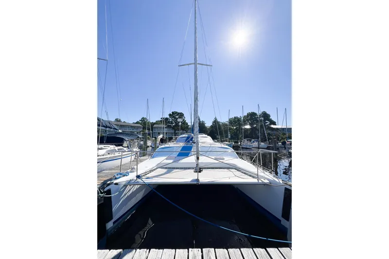 Slide: The Image of Sailboat TomCat 9.70 s, 2012 model, docked under clear blue sky. - 4