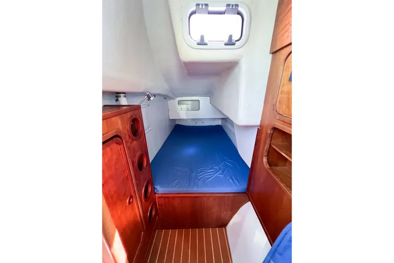 Slide: The Image of Interior cabin of 2012 TomCat 9.70 s sailboat with wooden cabinetry and blue bedding. - 41