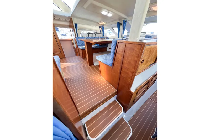 Slide: The Image of Interior of 2012 TomCat 9.70 s boat with wooden flooring and blue seating. - 42
