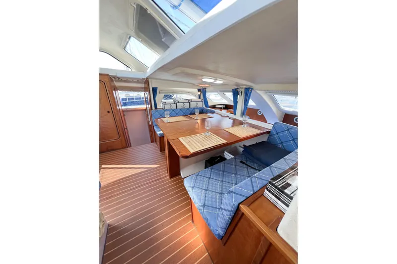 Slide: The Image of Interior of 2012 TomCat 9.70 s sailboat with cozy seating and wooden table. - 44