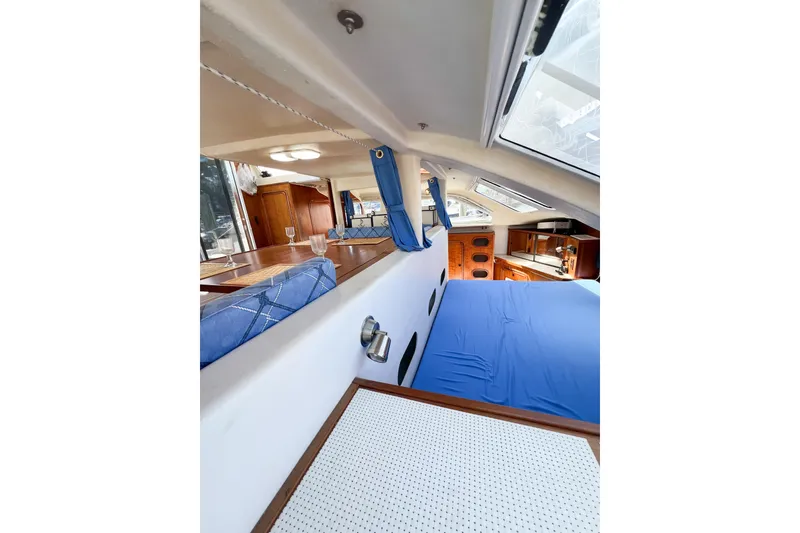 Slide: The Image of Interior of 2012 TomCat 9.70 s catamaran with blue bedding and wooden cabinetry. - 47