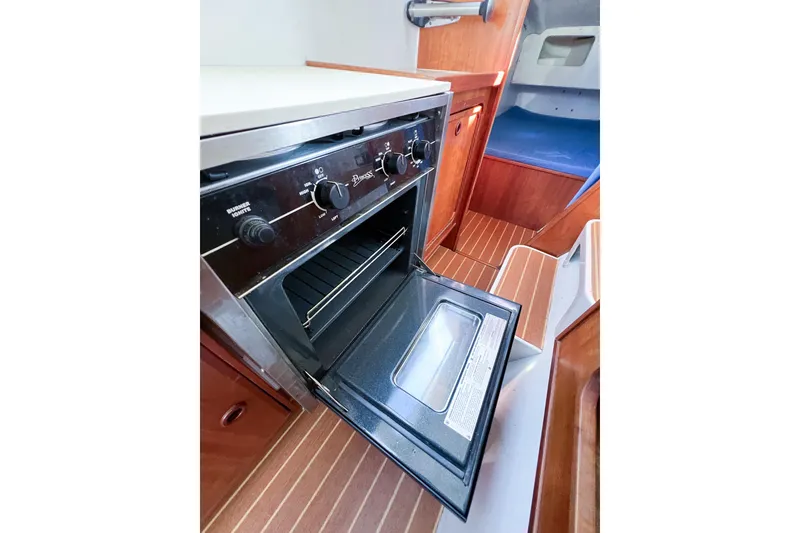 Slide: The Image of Boat interior with open oven, wooden flooring, and seating area, TomCat 9.70 s, 2012 model. - 49