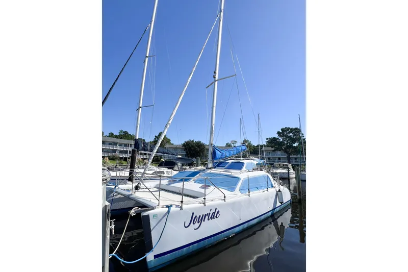Slide: The Image of 2012 TomCat 9.70 s catamaran named "Joyride" docked at a marina under clear blue sky. - 5