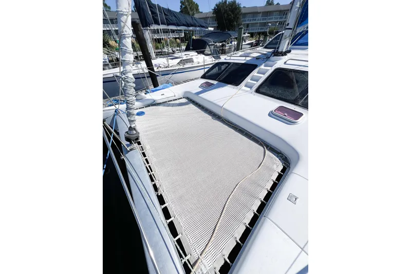Slide: The Image of 2012 TomCat 9.70 s catamaran with netting on deck, docked at marina. - 50