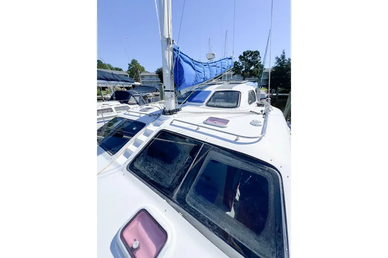Slide: The Image of 2012 TomCat 9.70 s sailboat with blue sail, docked in marina. - 51