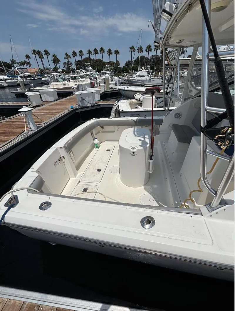 Slide: The Image of 2006 Tiara Yachts 2900 boat docked at marina, featuring spacious deck and seating area. - 15