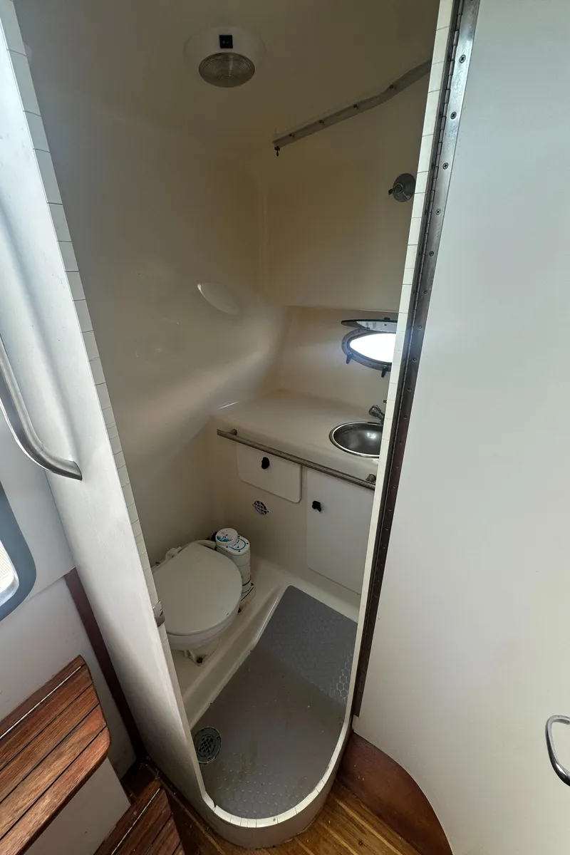 Slide: The Image of Compact bathroom in a 2006 Tiara Yachts 2900, featuring a toilet, sink, and shower. - 23