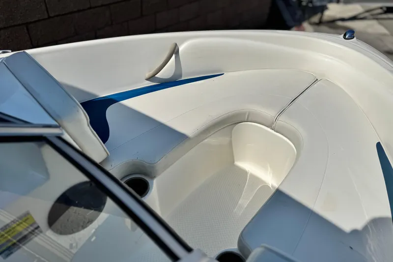 Slide: The Image of 2004 Bayliner 175 Bowrider interior with white seating and blue accents. - 10