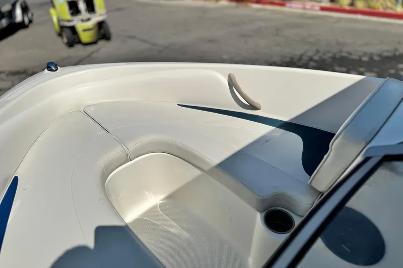 Slide: The Image of 2004 Bayliner 175 Bowrider boat interior with white seating and cup holder. - 11