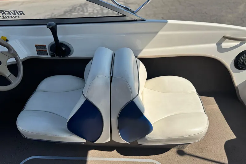 Slide: The Image of 2004 Bayliner 175 Bowrider interior with white and blue seating, steering wheel, and controls. - 21