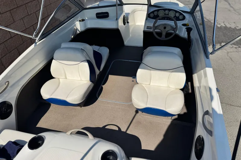 Slide: The Image of 2004 Bayliner 175 Bowrider interior with white seats and steering wheel, showcasing spacious design. - 7