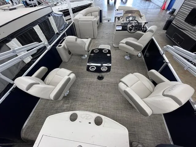 Slide: The Image of 2020 Harris Cruiser 210 pontoon boat interior with beige seating and central table. - 7