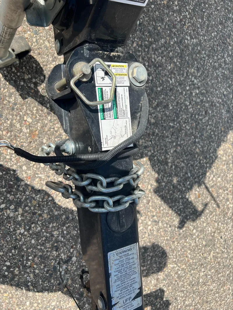 Slide: The Image of Trailer hitch of a 2016 Crestliner Raptor 1850, secured with chains on asphalt. - 16