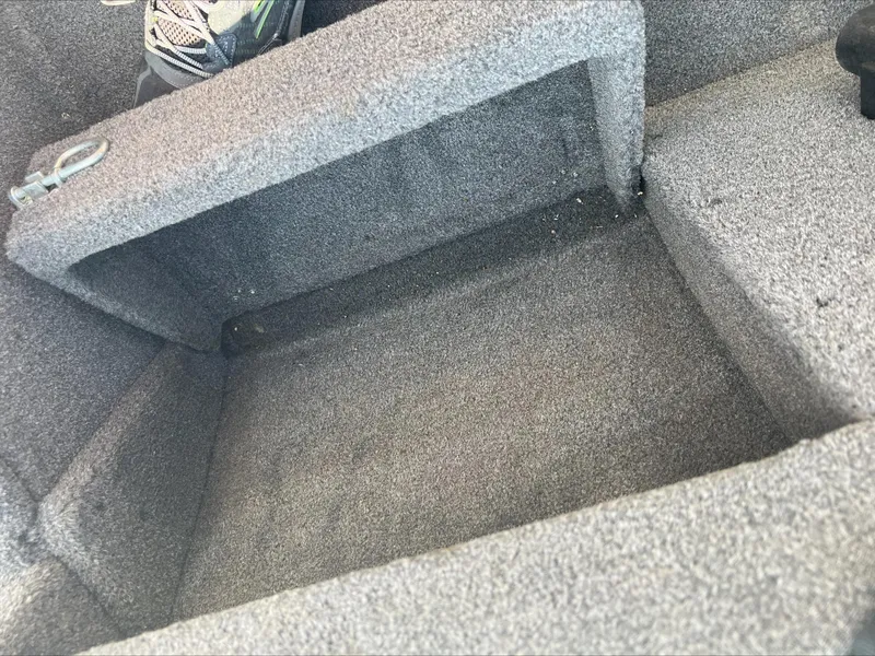 Slide: The Image of Open storage compartment in 2016 Crestliner Raptor 1850 boat, with carpeted interior. - 9