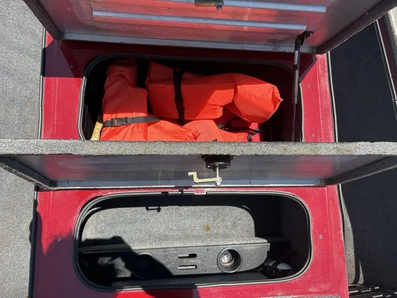 Slide: The Image of Open storage compartment in 2019 Tracker Pro Team™ 195 TXW boat with orange life jackets. - 10