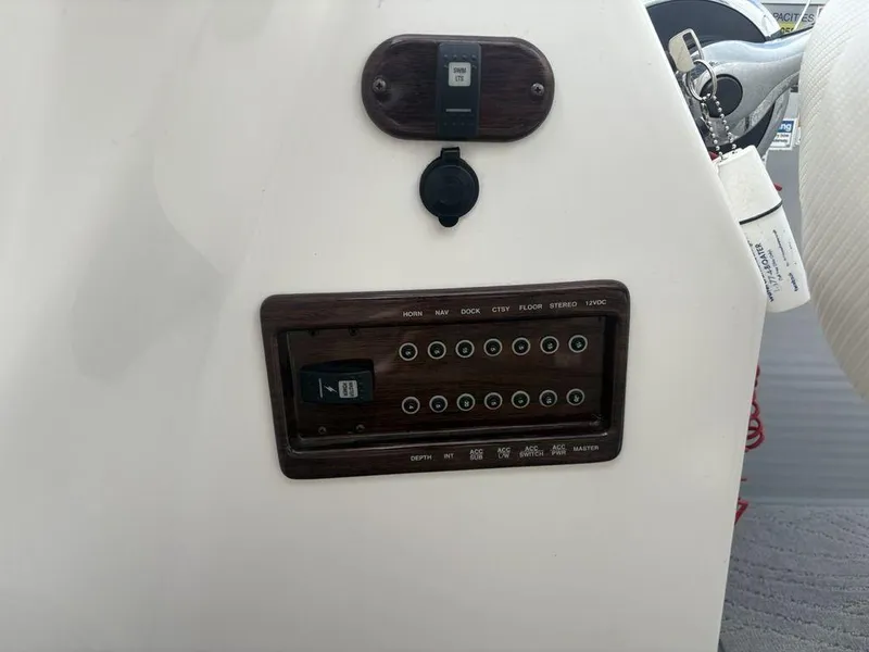 Slide: The Image of Control panel of a 2013 Godfrey AP250 RL boat with switches and keychain. - 16