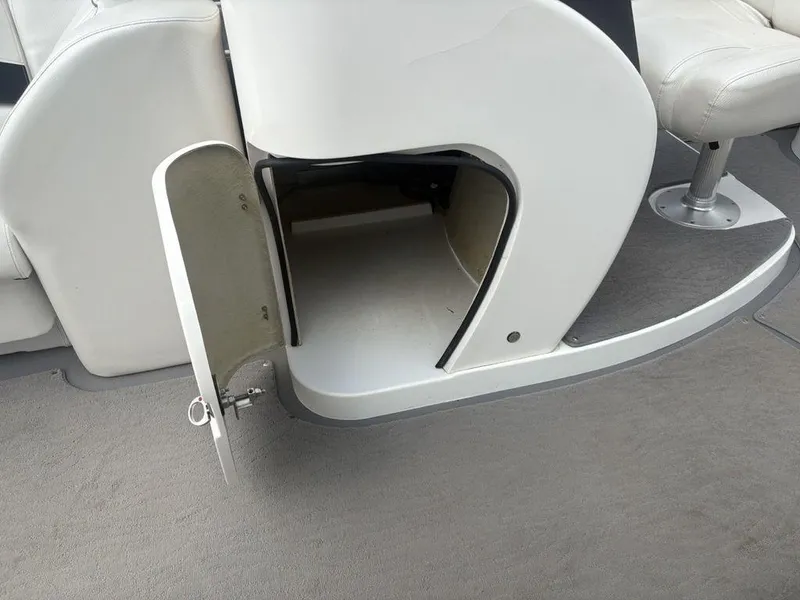 Slide: The Image of Open storage compartment on a 2013 Godfrey AP250 RL boat, featuring white seating and gray flooring. - 20