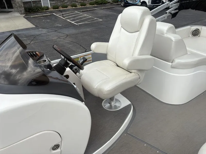Slide: The Image of Captain's chair and helm of 2013 Godfrey AP250 RL boat, featuring sleek design and controls. - 21