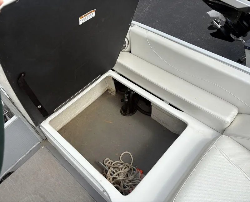 Slide: The Image of Open storage compartment on a 2013 Godfrey AP250 RL boat with rope inside. - 29