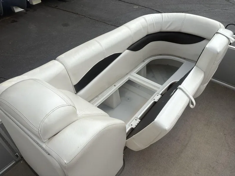 Slide: The Image of White leather seating on a 2013 Godfrey AP250 RL boat, showcasing storage compartment. - 9