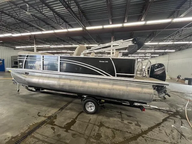 The Image of 2017 Harris Cruiser 200 pontoon boat in a warehouse, on a trailer. - 1