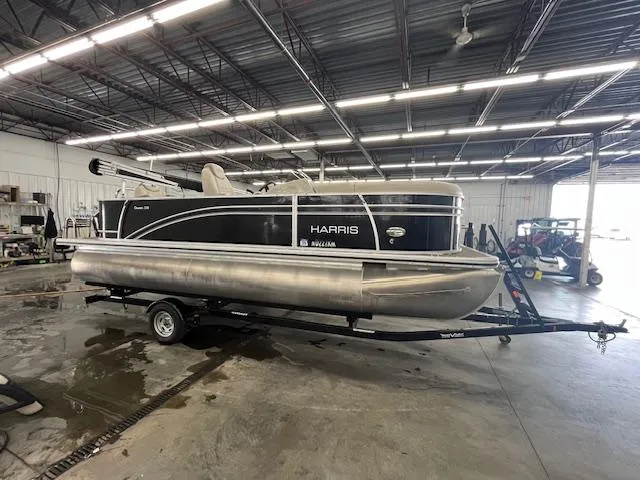 Slide: The Image of 2017 Harris Cruiser 200 pontoon boat in a warehouse setting on a trailer. - 3