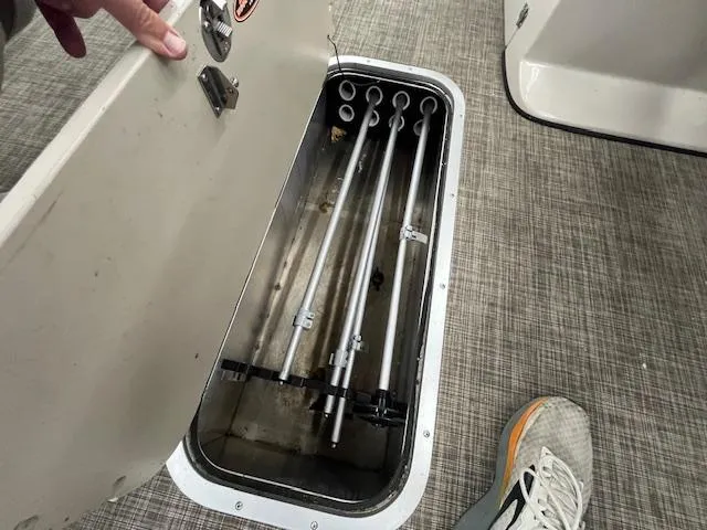 Slide: The Image of Storage compartment in a 2017 Harris Cruiser 200 boat, containing metal rods. - 4