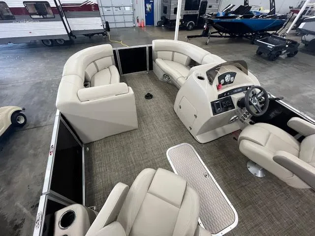 Slide: The Image of 2017 Harris Cruiser 200 pontoon boat interior with beige seating and steering console in a showroom. - 5
