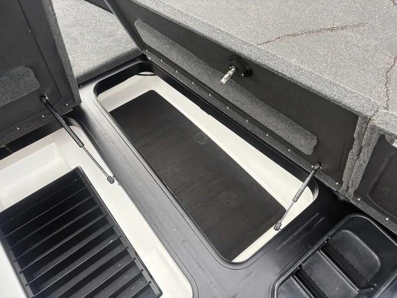 Slide: The Image of 2023 Skeeter ZXR 20 boat storage compartments with open lids and hydraulic supports. - 12