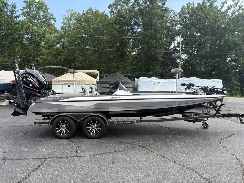 Slide: The Image of 2023 Skeeter ZXR 20 boat with powerful outboard motor, parked on a trailer in a lot. - 5
